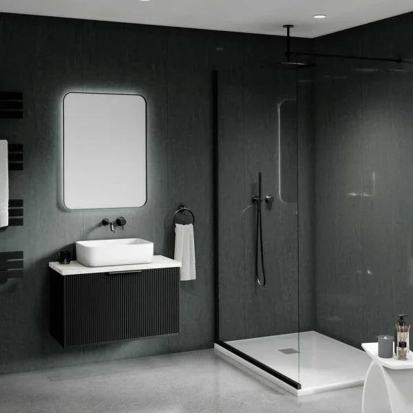 Modern bathroom interior with a floating black vanity, white vessel sink, rectangular mirror, walk-in shower with glass enclosure, dark textured walls, and a small white side table in the foreground.
