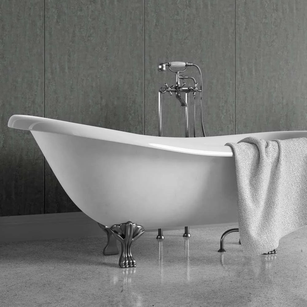 White freestanding bathtub with a shower head against a black wall on a patterned floor.
