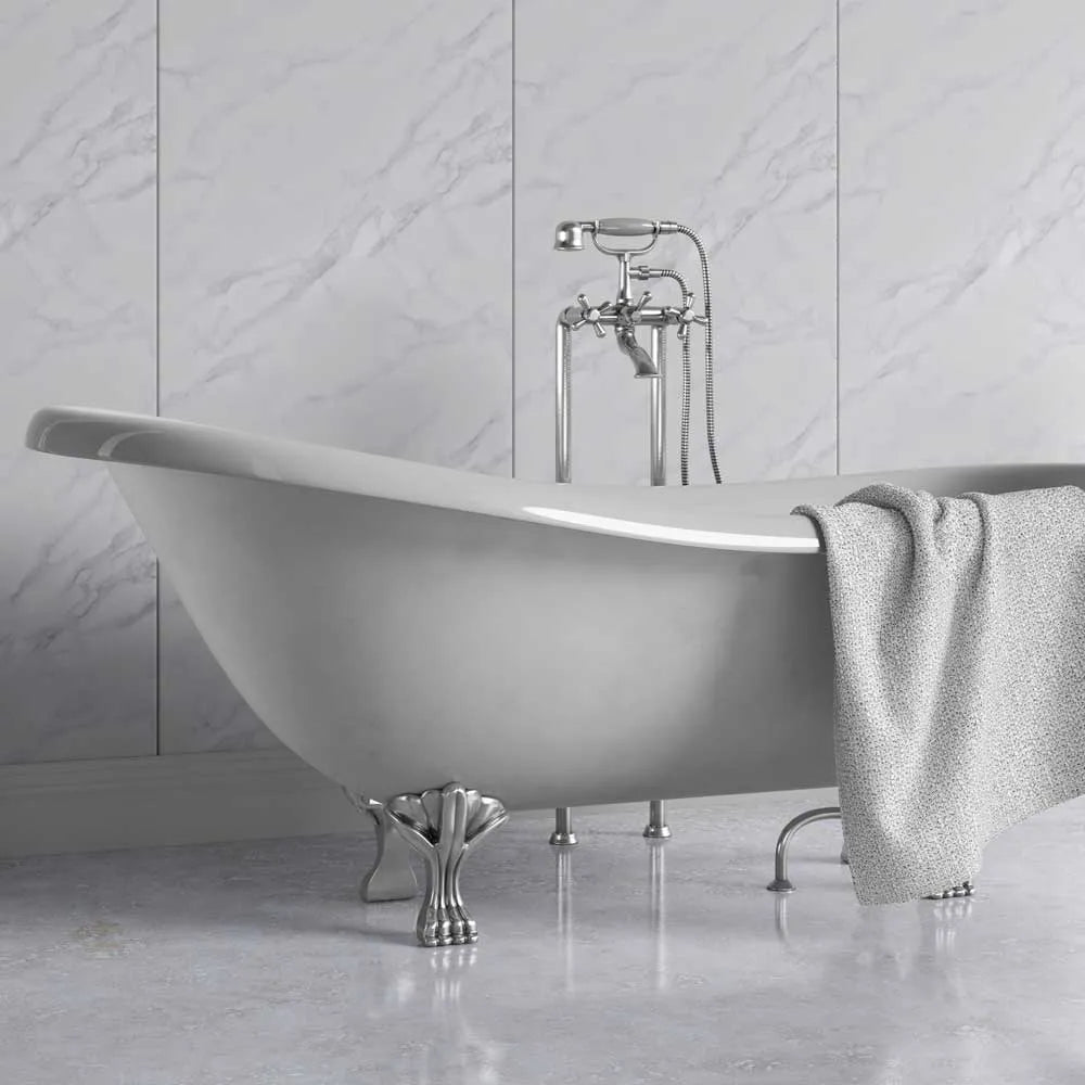 A freestanding oval bathtub with claw feet and a polished chrome faucet set, shown in a bathroom with light marble wall and floor tiles. A textured light gray towel is draped over the side of the tub.