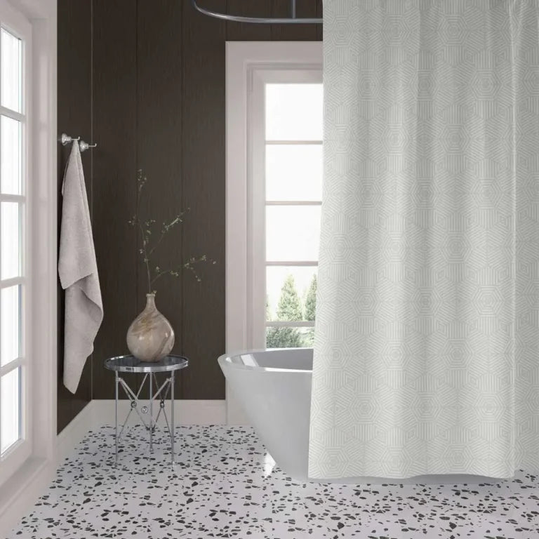 A white textured shower curtain hanging in a modern bathroom with dark wood paneled walls, a white freestanding tub, and a black-and-white speckled floor.