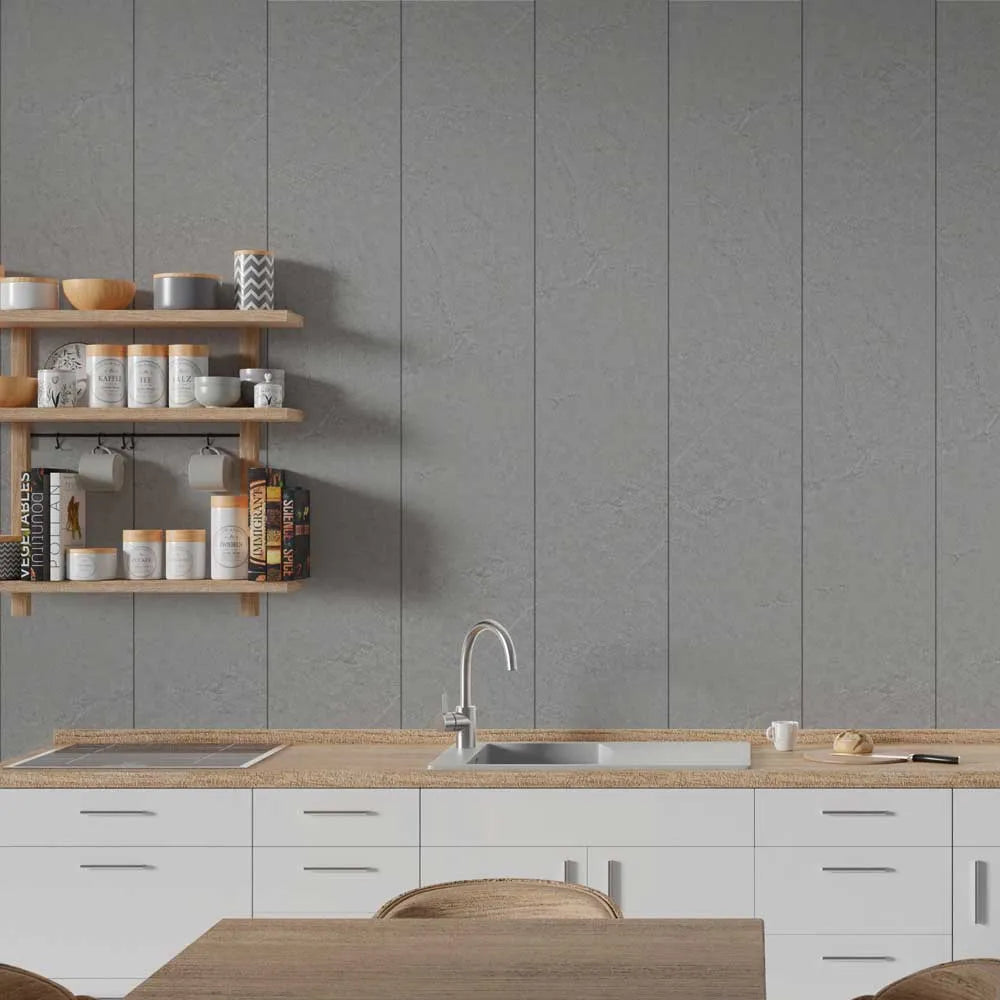A modern kitchen interior with a gray paneled wall, white lower cabinets, a light wood countertop, a built-in sink, and floating wooden shelves holding jars and bowls.