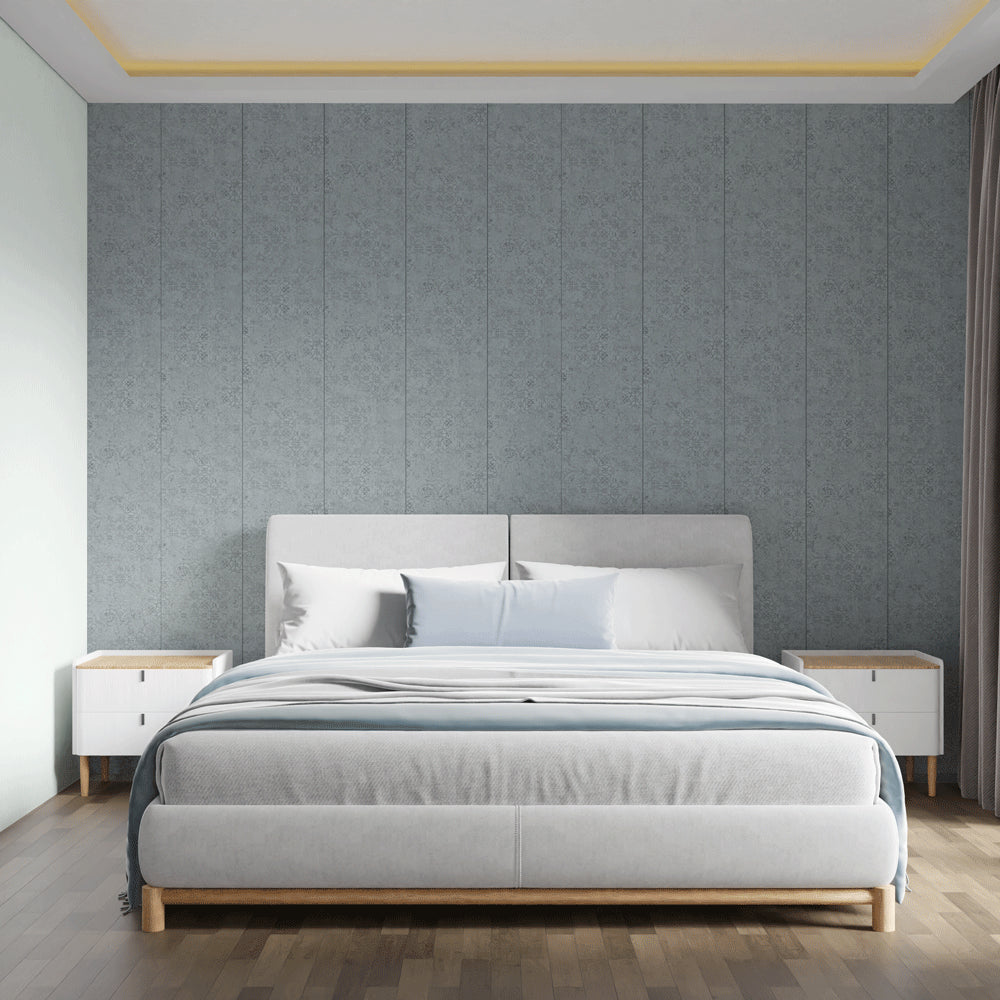 A modern bedroom featuring a light gray upholstered bed frame with a wooden base, styled with white and light blue bedding. The bed is centered against a textured gray paneled wall, flanked by two white nightstands with light wood tops, on a dark wood floor.