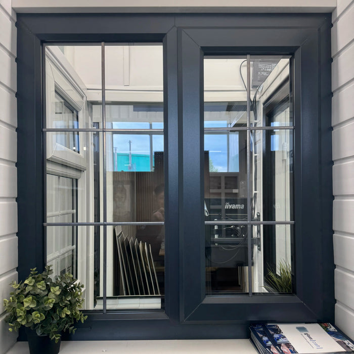 Window with black frame and white trim, featuring a view of an interior space.