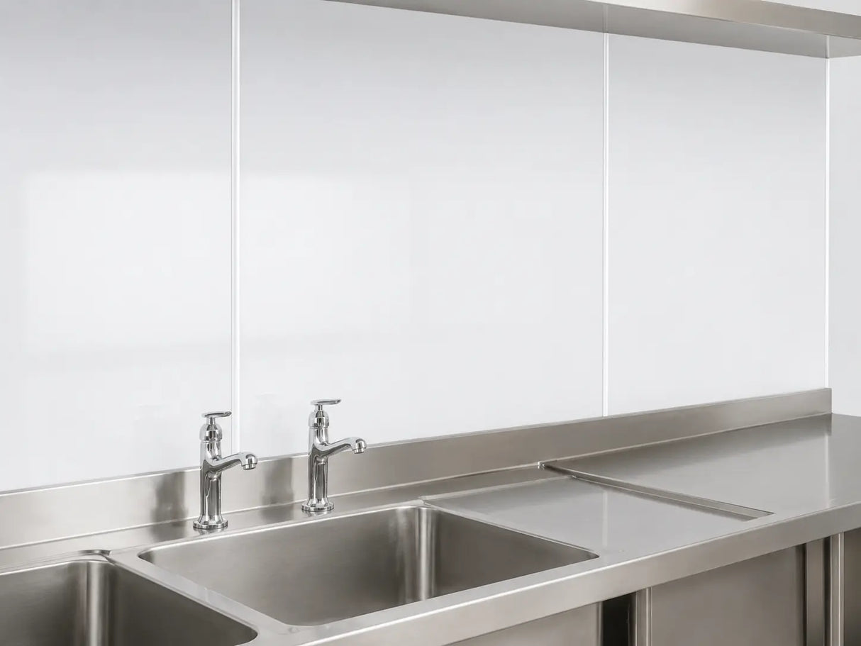White 3mm hygienic wall panels with cover strip joints installed behind stainless steel commercial sinks