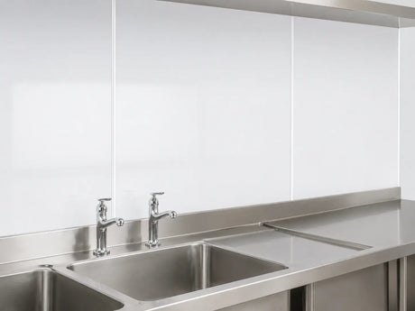White 3mm hygienic wall panels with cover strip joints installed behind stainless steel commercial sinks