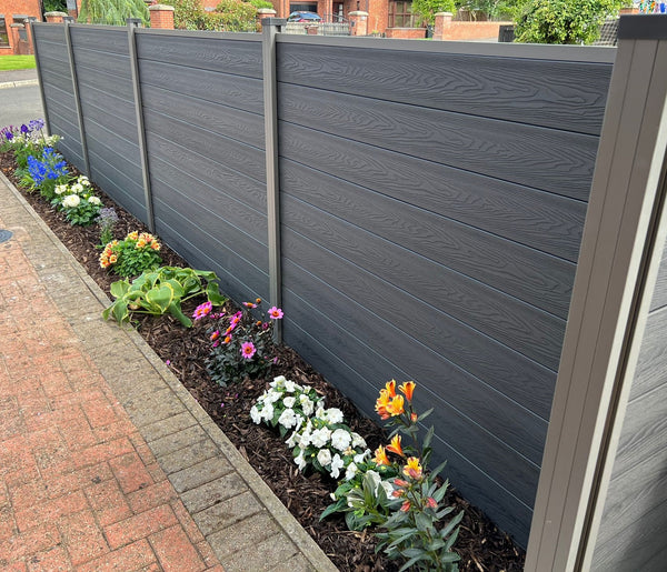 Gray wooden fence with a flower bed in front