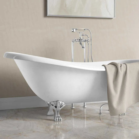 A freestanding oval bathtub with ornate silver claw feet and a matching chrome wall-mounted faucet, shown in a bathroom setting with a beige towel draped over the side.