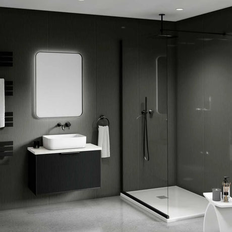 Modern bathroom interior with a floating black vanity, white vessel sink, rectangular mirror, walk-in shower with glass enclosure, dark textured walls, and a small white side table in the foreground.