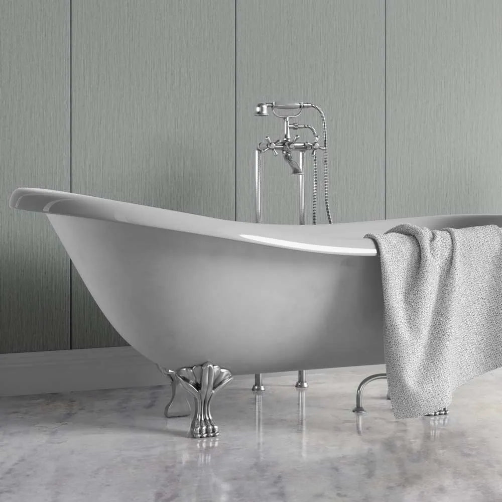 A freestanding oval bathtub with silver claw feet and a matching chrome faucet, shown in a bathroom setting with a gray towel draped over the side and a paneled wall behind it.