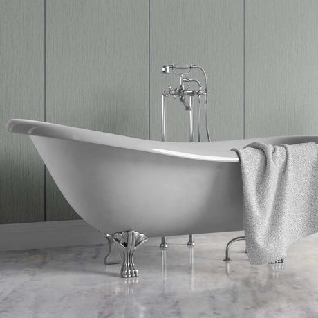 A freestanding oval bathtub with silver claw feet and a matching chrome faucet, shown in a bathroom setting with a gray towel draped over the side and a paneled wall behind it.