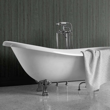 A freestanding white bathtub with ornate silver claw legs and a matching chrome faucet, shown in a bathroom setting with a gray textured towel draped over the side.