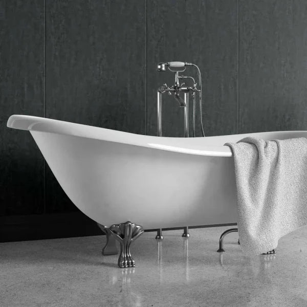 A freestanding white bathtub with ornate silver claw legs and a matching chrome faucet, shown in a bathroom setting with a gray textured towel draped over the side.