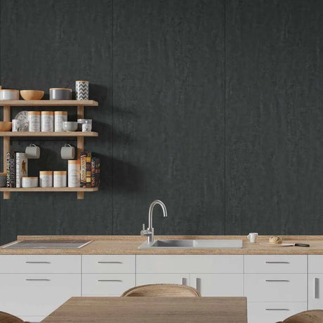 A modern kitchen scene with a large dark charcoal textured wall panel behind a light wood countertop, white cabinets, a sink, and floating wooden shelves holding dishes and mugs.