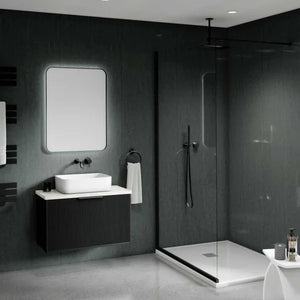 Modern bathroom interior with a floating black vanity, white vessel sink, rectangular mirror, walk-in shower with glass enclosure, dark textured walls, and a small white side table in the foreground.