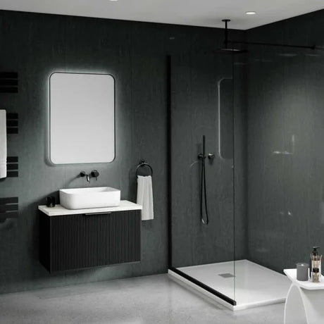 Modern bathroom interior with a floating black vanity, white vessel sink, rectangular mirror, walk-in shower with glass enclosure, dark textured walls, and a small white side table in the foreground.