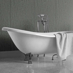 White freestanding bathtub with a shower head against a black wall on a patterned floor.