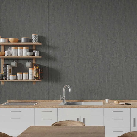 A modern kitchen interior with white cabinets, a light wood countertop, a stainless steel sink and faucet, and a dark textured wall. Floating wooden shelves on the left hold jars, bowls, and decorative items.