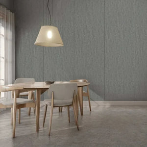 A modern dining room scene with a round light wood table and four upholstered dining chairs in a neutral gray setting, under a hanging pendant lamp against a paneled gray wall.