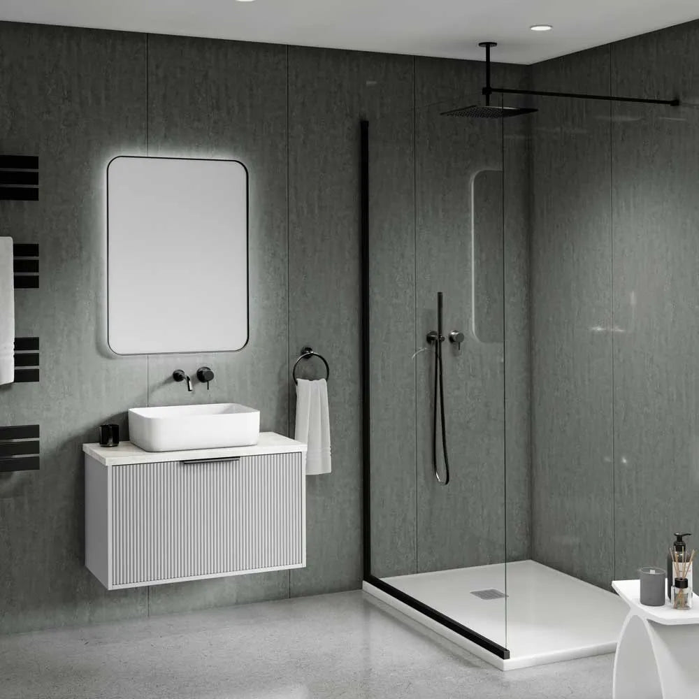 Modern floating bathroom vanity with a white rectangular sink, a large rectangular mirror, and a ribbed white cabinet set against dark gray textured walls. A glass shower enclosure with black trim is visible to the right.