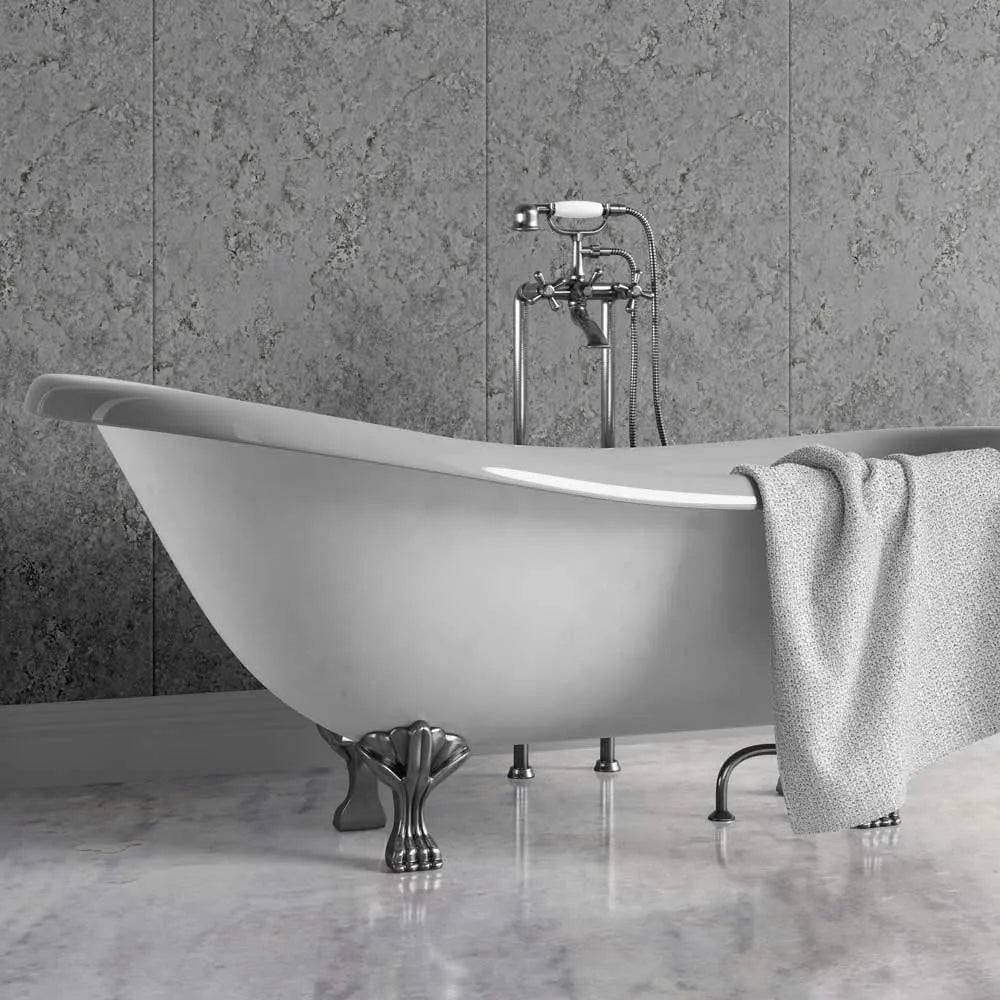 A freestanding white clawfoot bathtub with polished silver metal legs and a matching chrome faucet set, shown in a bathroom setting with gray stone wall panels and a marble floor. A light gray towel is draped over the side.