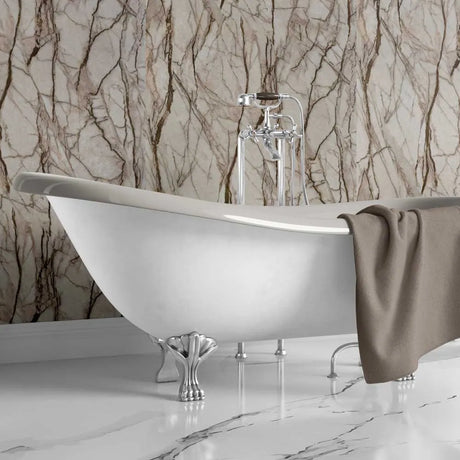 White freestanding bathtub with a brown towel against a marble-patterned wall.