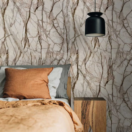 Bedroom with textured wall paper, wooden nightstand, and pillows.