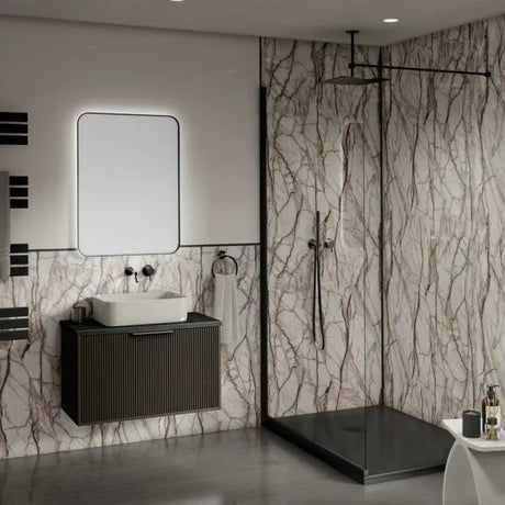 Modern bathroom with marble walls, a sink, and shower area.