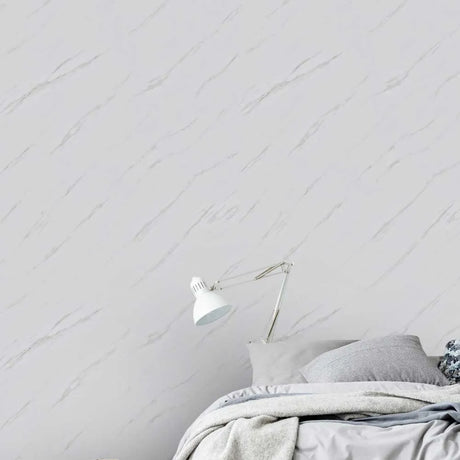 Bedroom with a white wall and a lamp, featuring a minimalistic design.