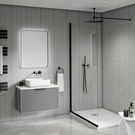 Modern bathroom interior with a floating gray vanity, white vessel sink, rectangular mirror, black fixtures, and a glass shower enclosure with black trim.
