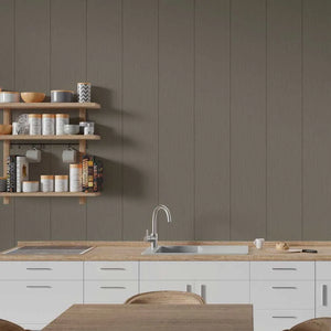 A modern kitchen interior with white cabinets, a light wood countertop, a stainless steel sink and faucet, open wooden wall shelves with jars and bowls, and a large taupe-brown paneled wall behind.