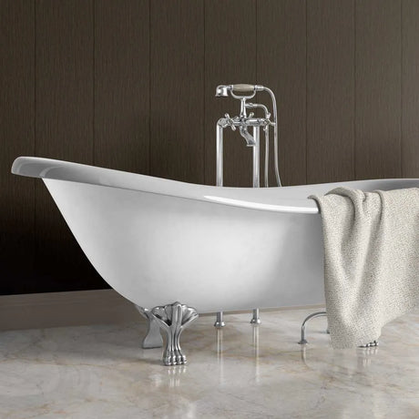 A white freestanding clawfoot bathtub with polished chrome faucet hardware and a draped beige towel, set against a dark wood-paneled wall and light marble floor.