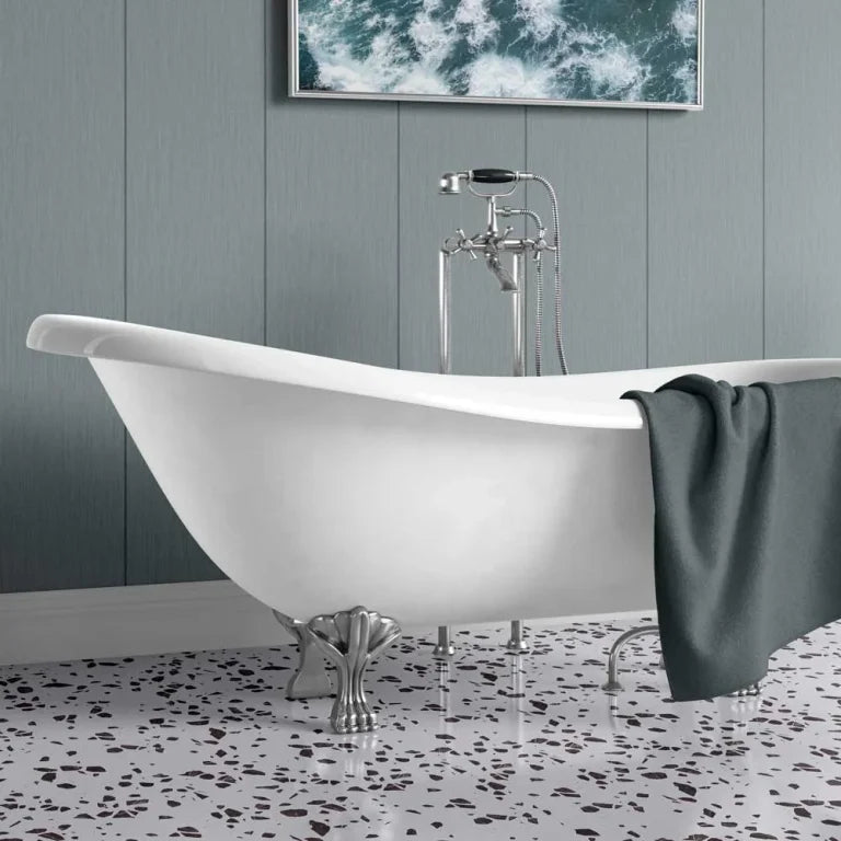 A freestanding oval bathtub with claw feet and a chrome faucet set, shown in a styled bathroom with gray paneled walls, a terrazzo floor, and a dark gray towel draped over the tub.