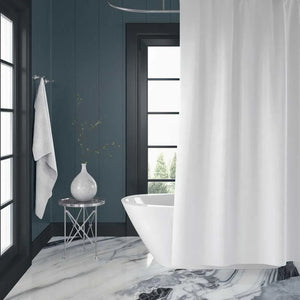 A white fabric shower curtain hanging in a modern bathroom with dark wood paneled walls, a freestanding white tub, and a marble floor.