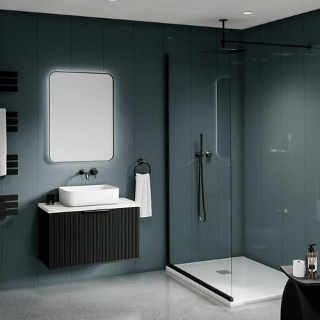 Modern bathroom interior with a dark floating vanity, white vessel sink, rectangular mirror, walk-in shower with glass door, and gray paneled walls and floor.