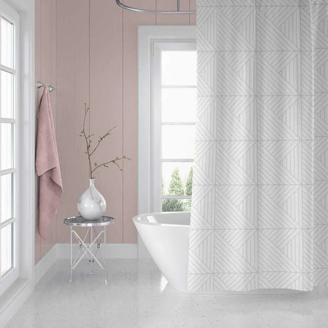 A white shower curtain with a light gray geometric line pattern hanging in a bright, modern bathroom with pink paneled walls, a white freestanding tub, and a small side table with a vase.