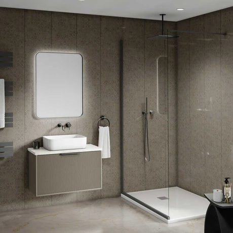 Modern bathroom interior featuring a floating vanity with a white vessel sink, a large rectangular mirror, a walk-in shower with clear glass doors, and textured taupe stone walls and floor.