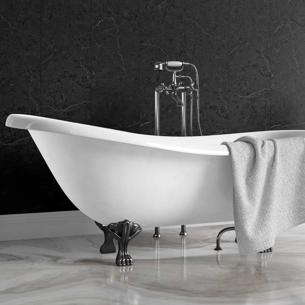 A freestanding white clawfoot bathtub with dark metal feet, set against a dark marble wall and light marble floor, with a gray towel draped over the side and a chrome faucet above.