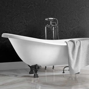 A freestanding white clawfoot bathtub with dark metal feet, set against a dark marble wall and light marble floor, with a gray towel draped over the side and a chrome faucet above.