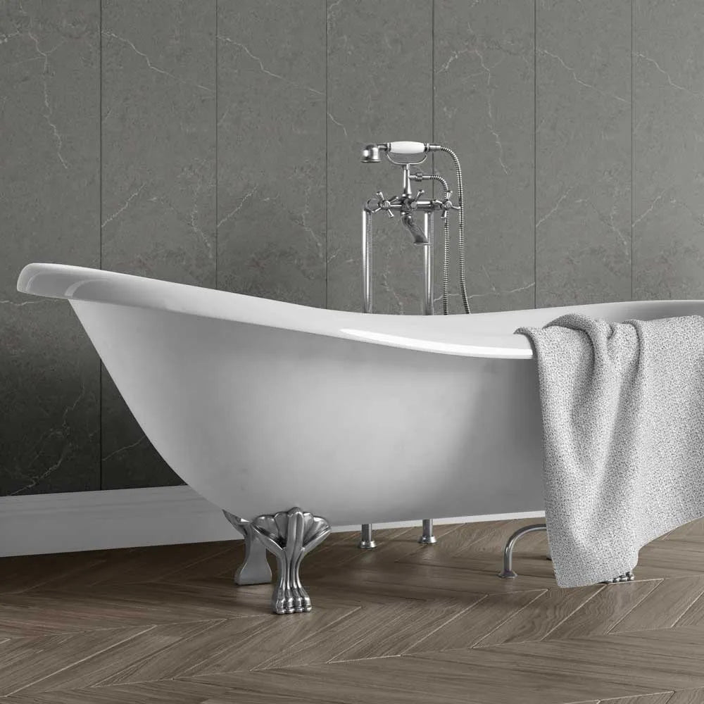 A white freestanding clawfoot bathtub with a chrome faucet and matching gray towel, set against a dark gray marble-look tiled wall and wood herringbone floor.