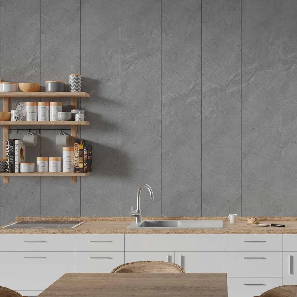 A modern kitchen interior with a large gray stone-look tiled backsplash, white lower cabinets, a light wood countertop, a built-in sink, and open wooden shelves holding jars and cookware.