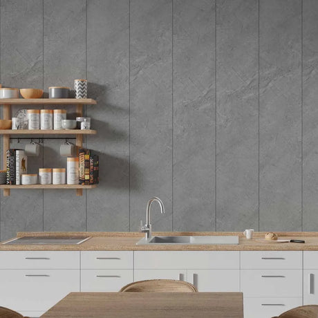 A modern kitchen interior with a large gray stone-look tiled backsplash, white lower cabinets, a light wood countertop, a built-in sink, and open wooden shelves holding jars and cookware.