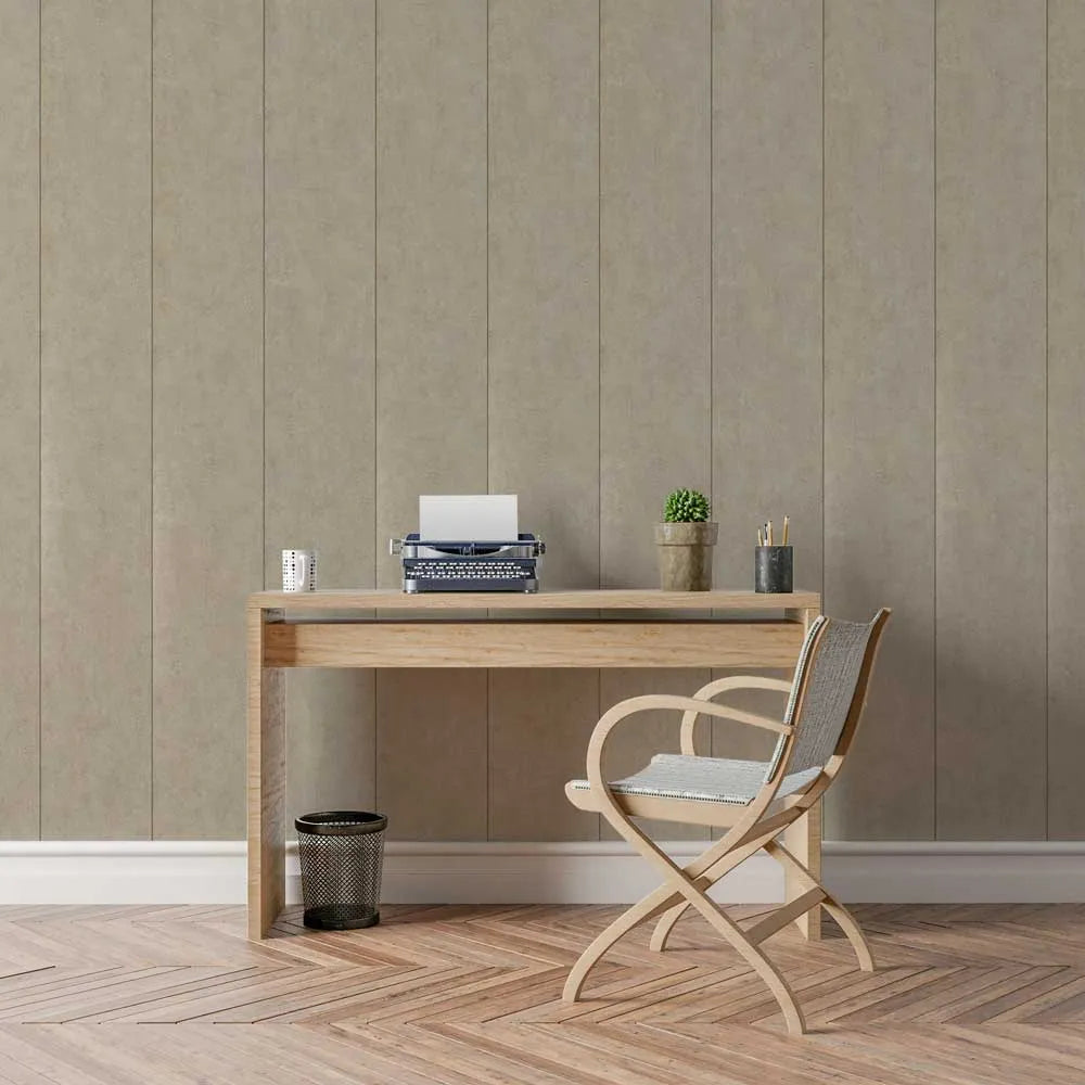 A minimalist home office setup featuring a light oak wood desk and a matching folding chair with a woven seat, set against a beige paneled wall and herringbone wood floor.