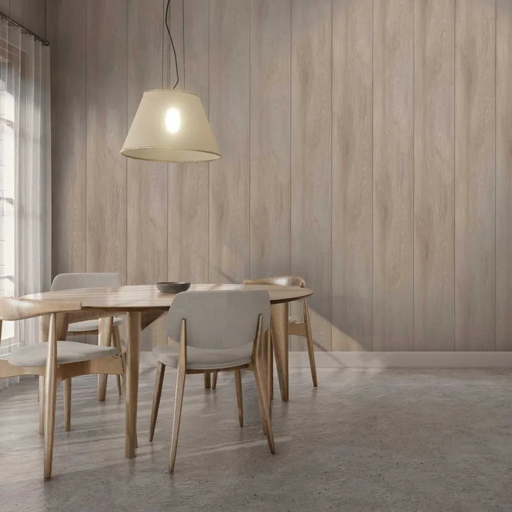 A modern dining room scene with a light wood table and four upholstered chairs, under a hanging pendant lamp against a wood-paneled wall.