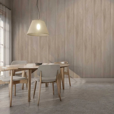A modern dining room scene with a light wood table and four upholstered chairs, under a hanging pendant lamp against a wood-paneled wall.
