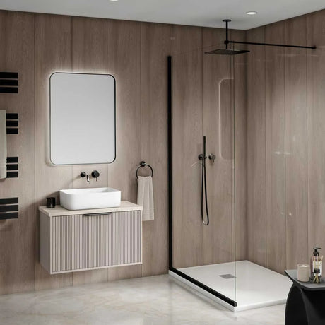 Modern bathroom interior featuring a floating vanity with a white vessel sink, a large rectangular mirror, and a walk-in shower with clear glass doors and black trim.