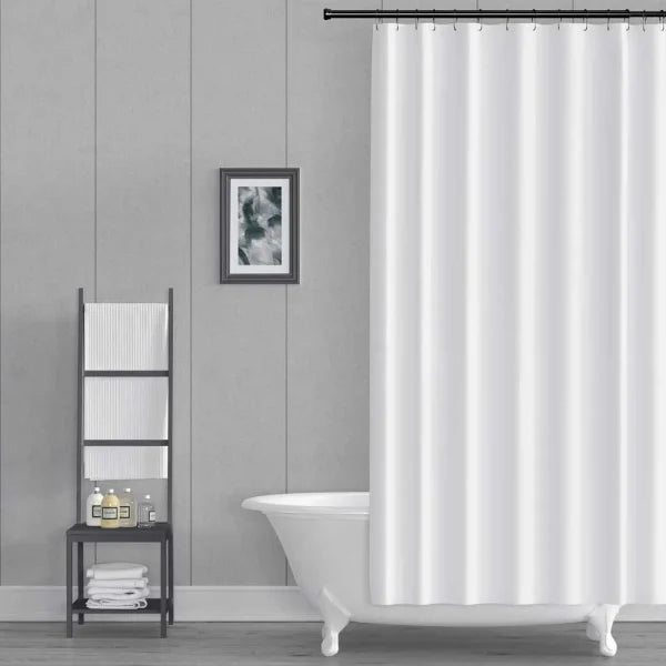 A white fabric shower curtain hanging from a black rod in a modern bathroom setting with a white clawfoot tub, a gray paneled wall, and a small black shelving unit.
