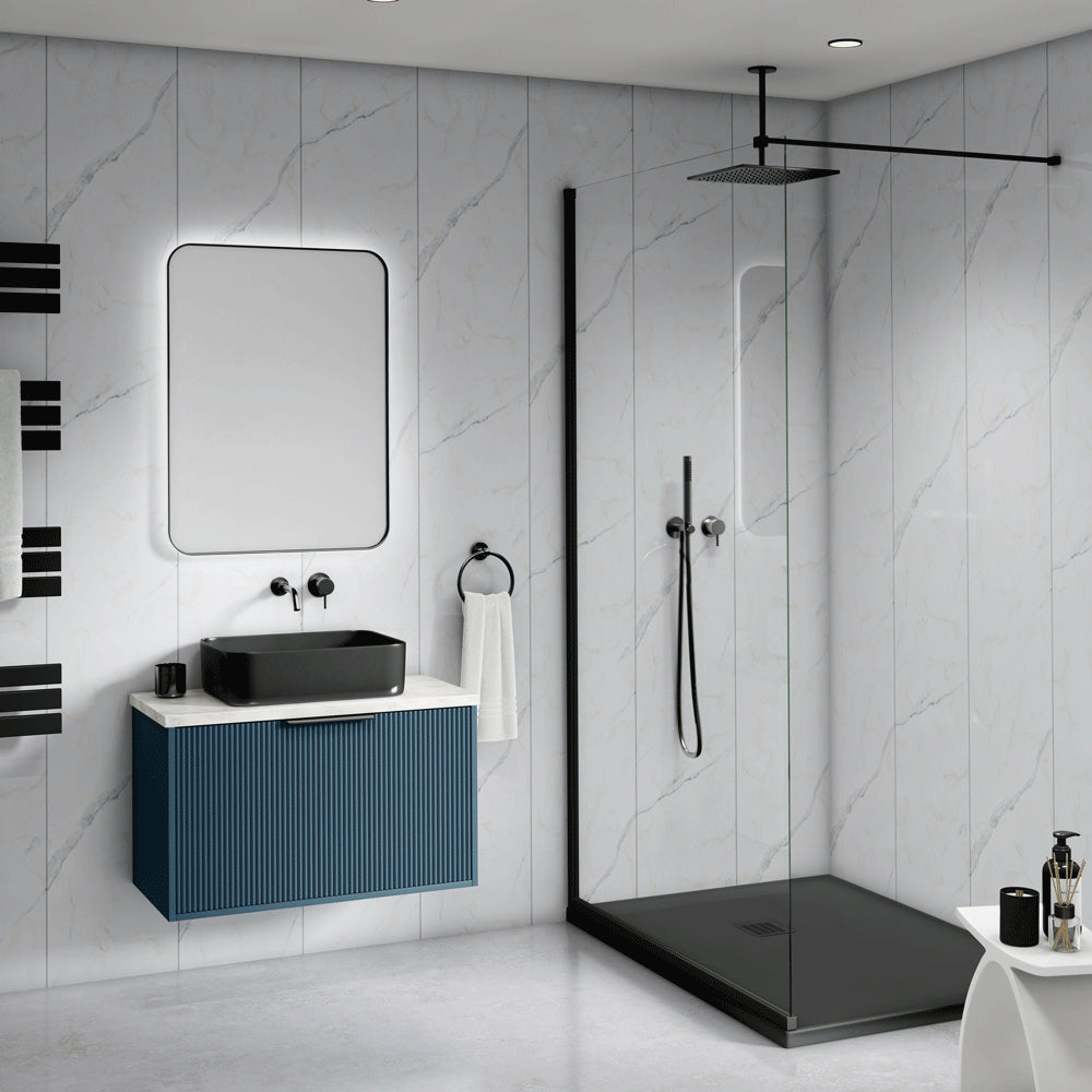 Modern bathroom interior featuring a floating blue vanity with a black vessel sink, a large rounded rectangular mirror with backlighting, and a glass shower enclosure with a black floor and base.
