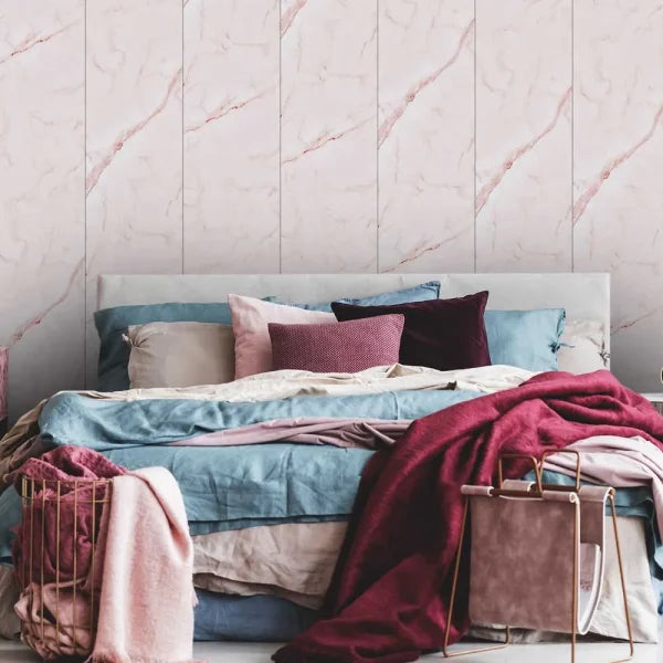 Bed with colorful bedding against a marble wall