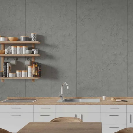 A modern kitchen interior featuring large gray stone-look wall tiles behind a white countertop with a built-in sink and faucet, plus light wood floating shelves with canisters and cookware.