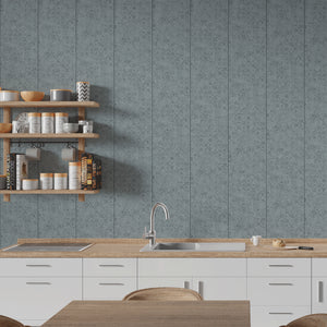 A kitchen interior with a blue-gray patterned wall, light wood countertops, white cabinets, a sink, and open wooden shelves holding jars and books.